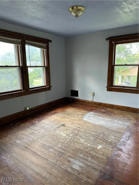 Spare room featuring a textured ceiling and baseboards