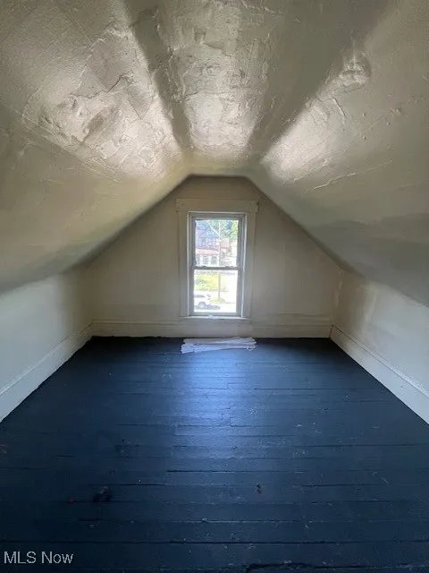 Bonus room featuring lofted ceiling and dark wood-style flooring