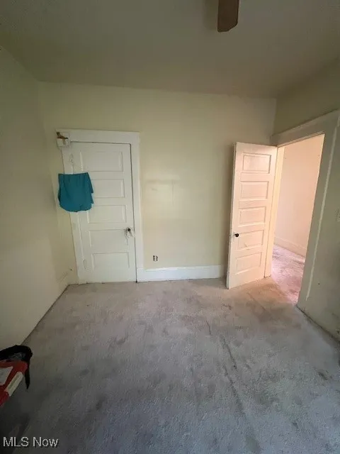 Unfurnished bedroom featuring carpet floors and ceiling fan