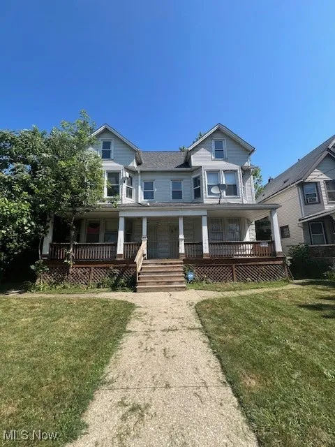View of front facade with covered porch and a front lawn