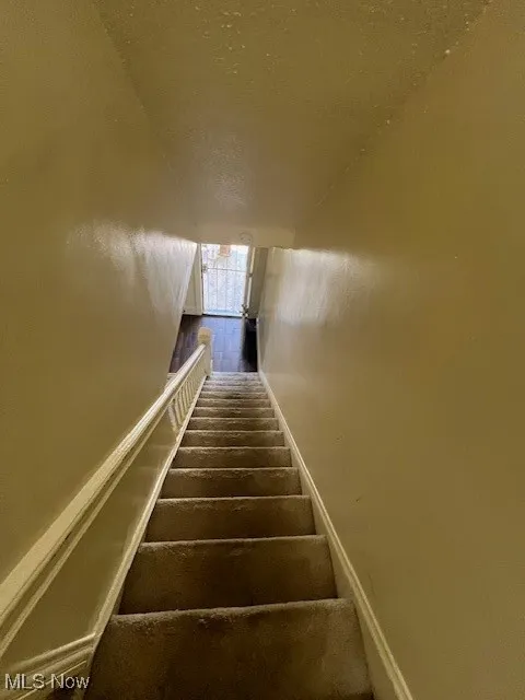 Staircase featuring baseboards