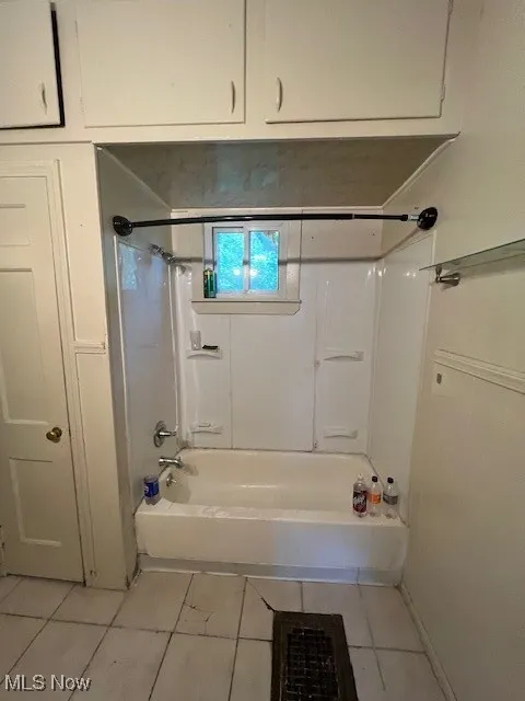 Full bath with shower / bath combination and tile patterned flooring
