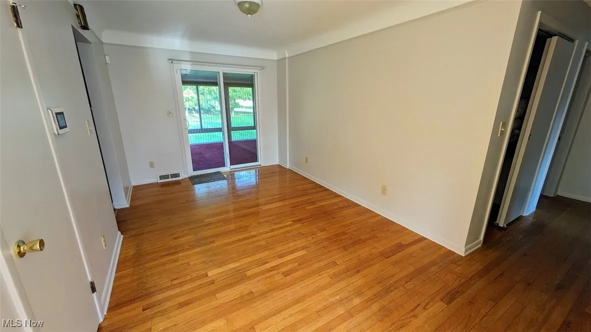 Spare room featuring light wood-type flooring and baseboards