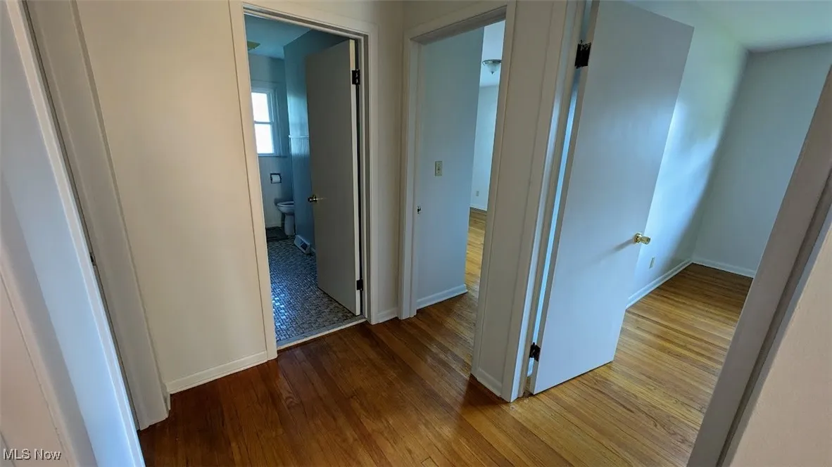 Hall with wood finished floors and baseboards