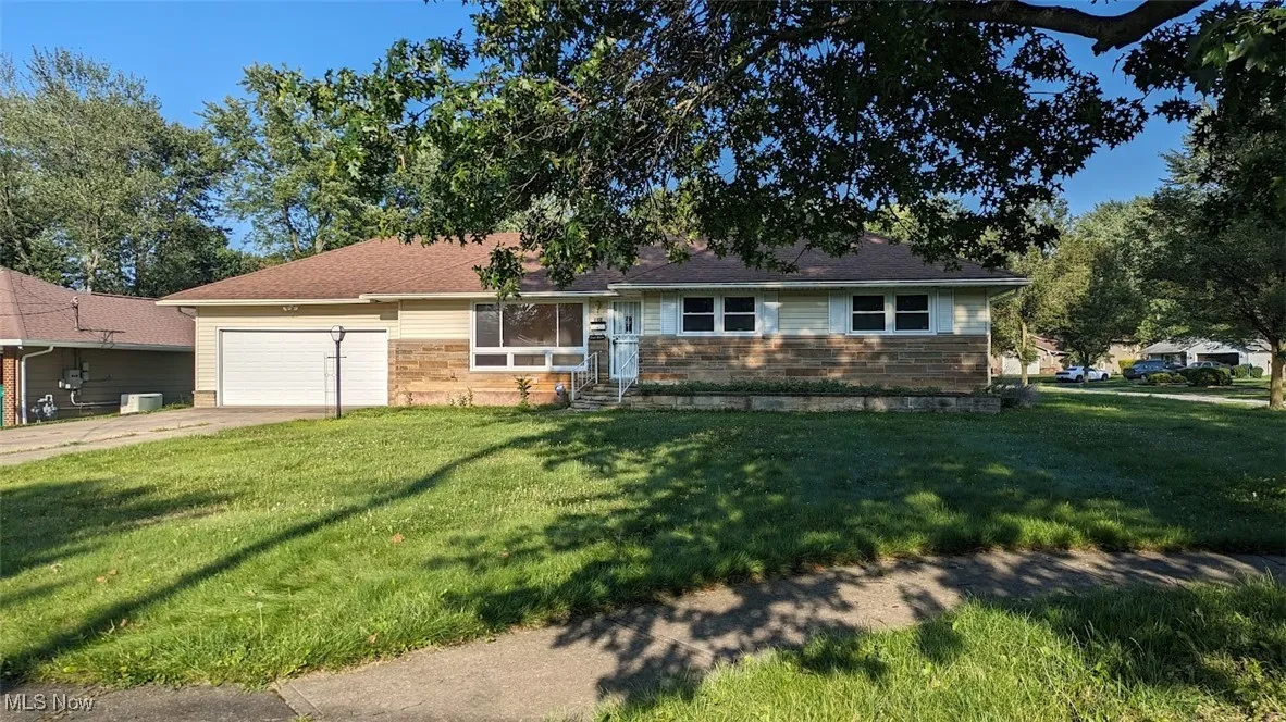 Ranch-style house featuring a garage, driveway, and a front yard