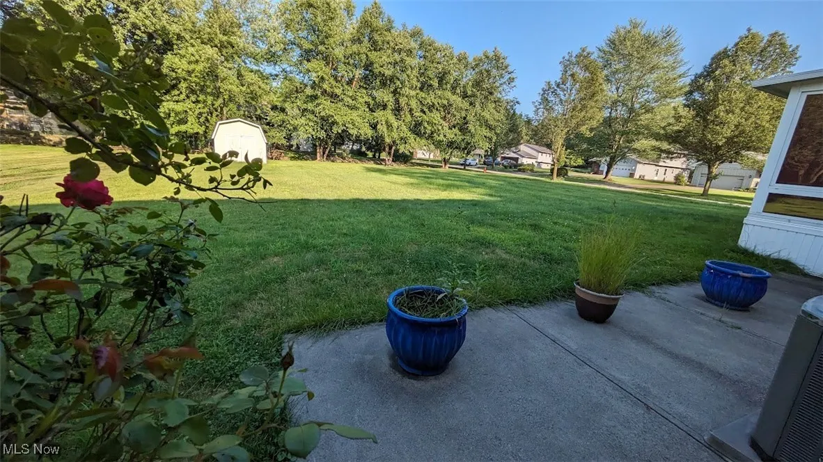 View of grassy yard featuring a patio