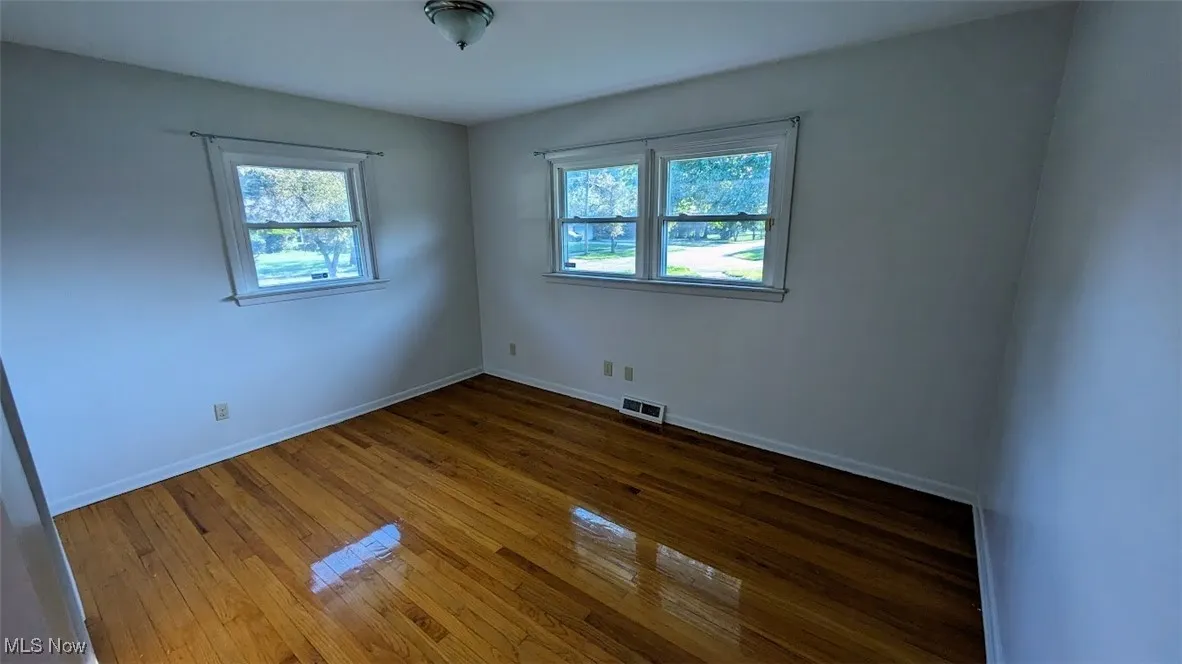 Unfurnished room with plenty of natural light and hardwood / wood-style flooring