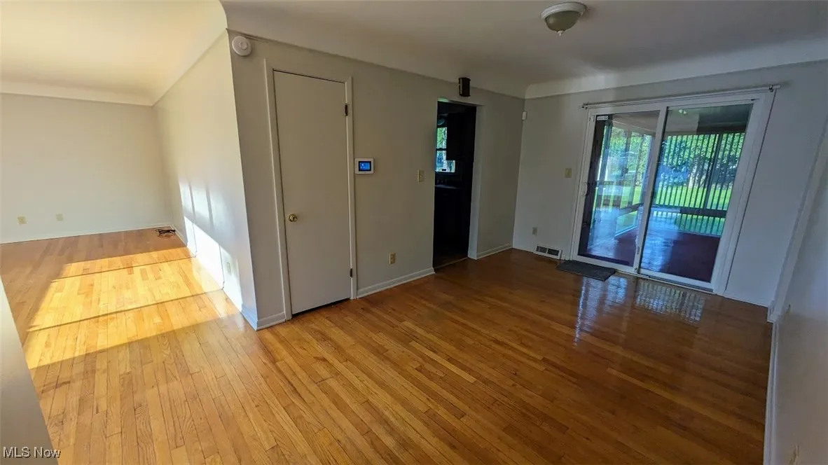 Unfurnished room with wood-type flooring and baseboards