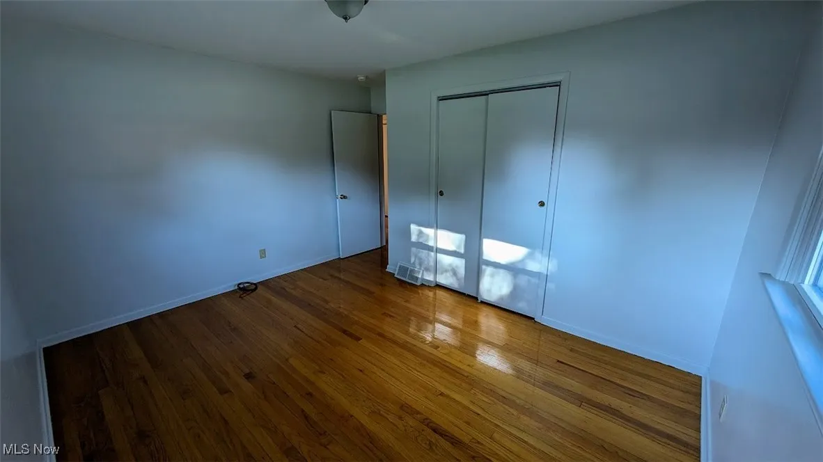 Unfurnished bedroom featuring wood finished floors and a closet