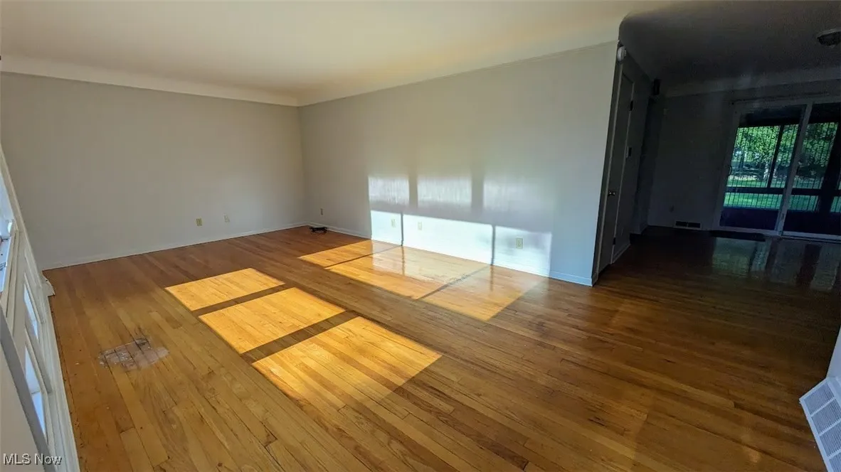 Empty room with hardwood / wood-style floors and baseboards