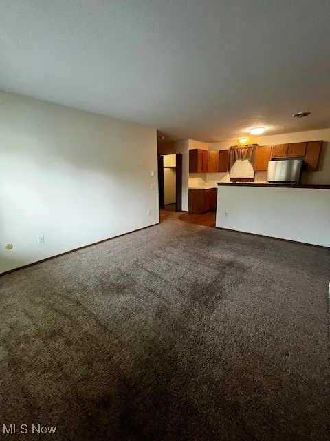 Unfurnished living room featuring carpet floors