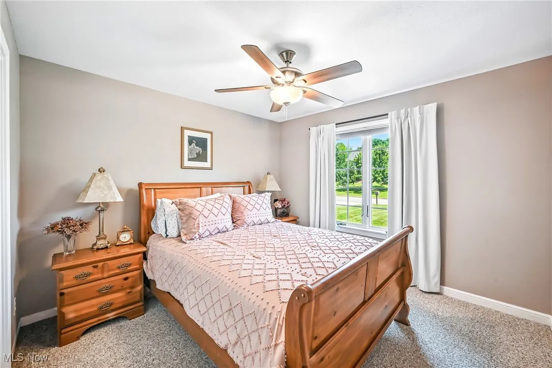 Carpeted bedroom featuring baseboards and a ceiling fan