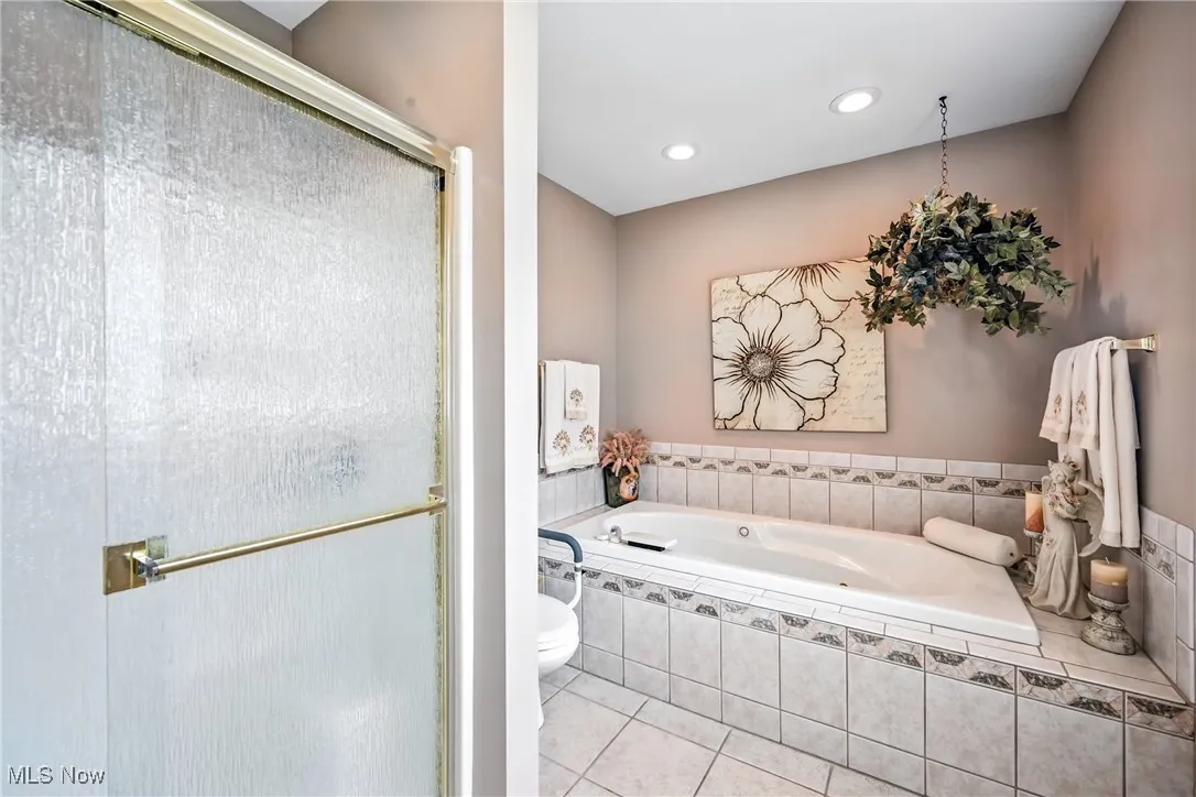 Bathroom featuring a bath, a shower stall, tile patterned flooring, and recessed lighting