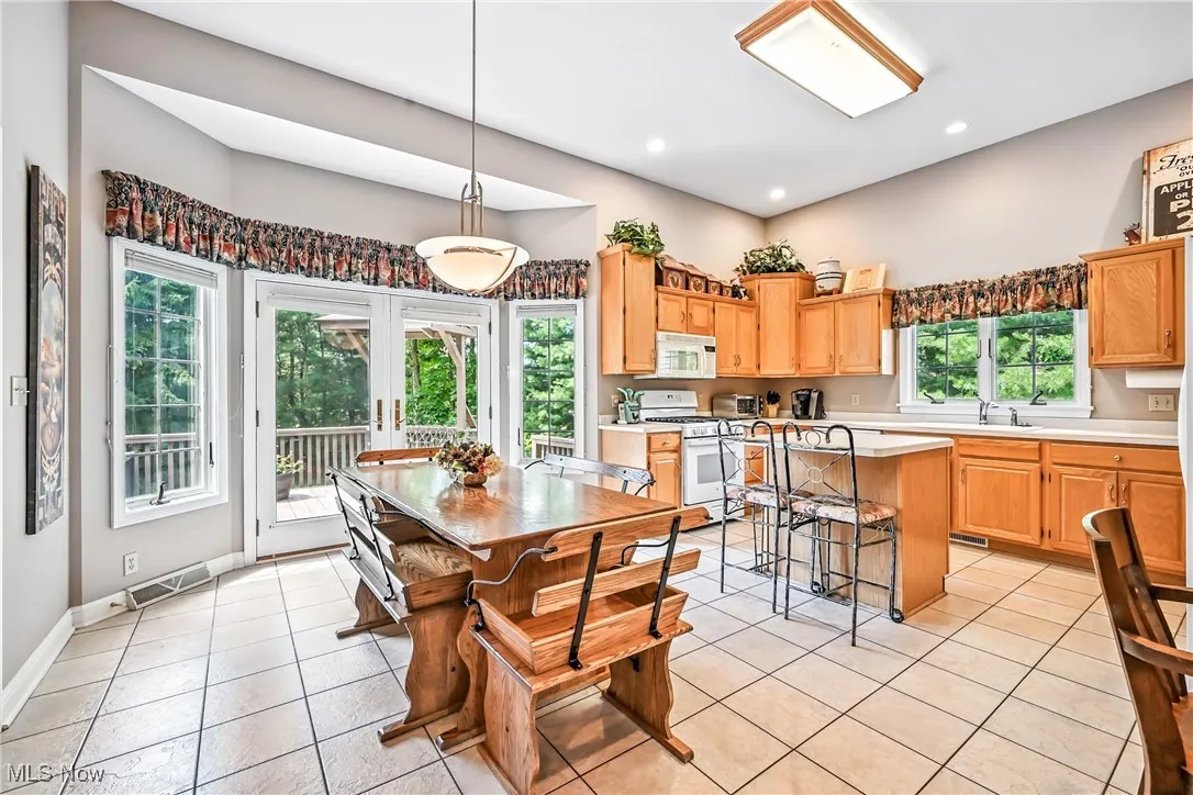 Dining room featuring light tile patterned floors, healthy amount of natural light, and recessed lighting