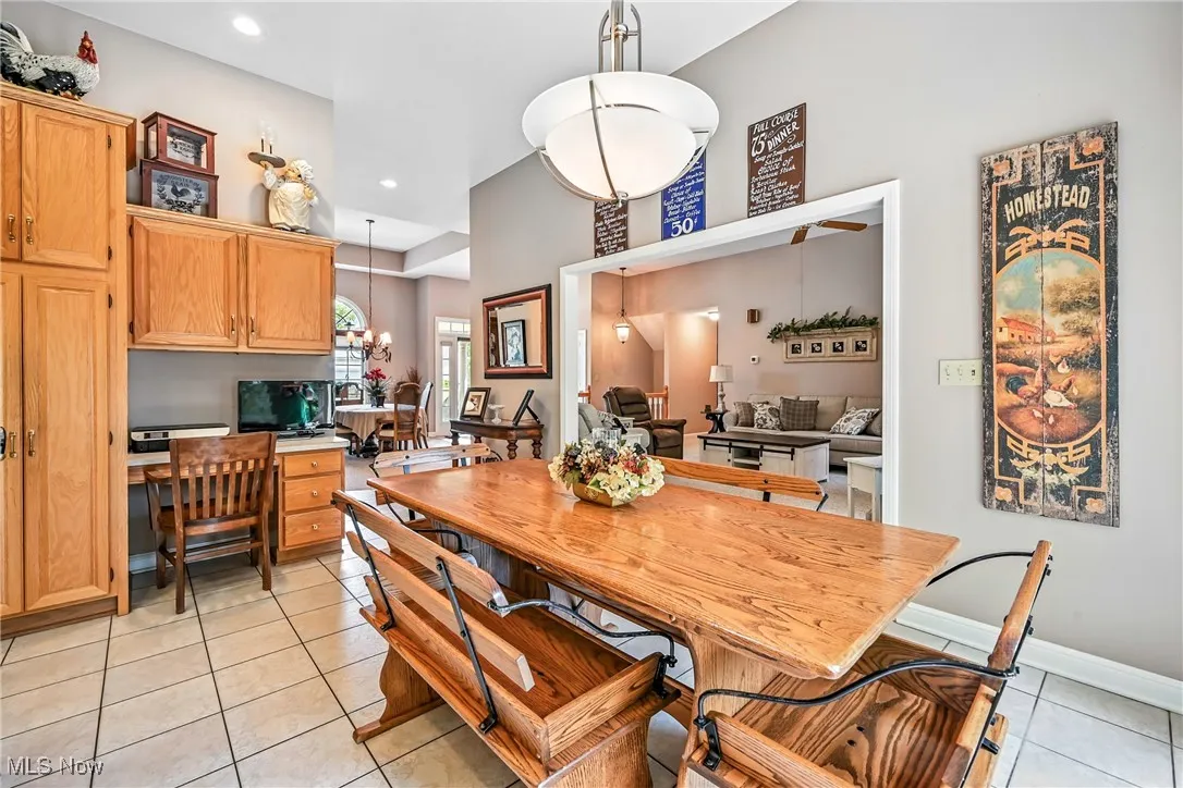 Dining space featuring light tile patterned floors, recessed lighting, an office area, and a high ceiling