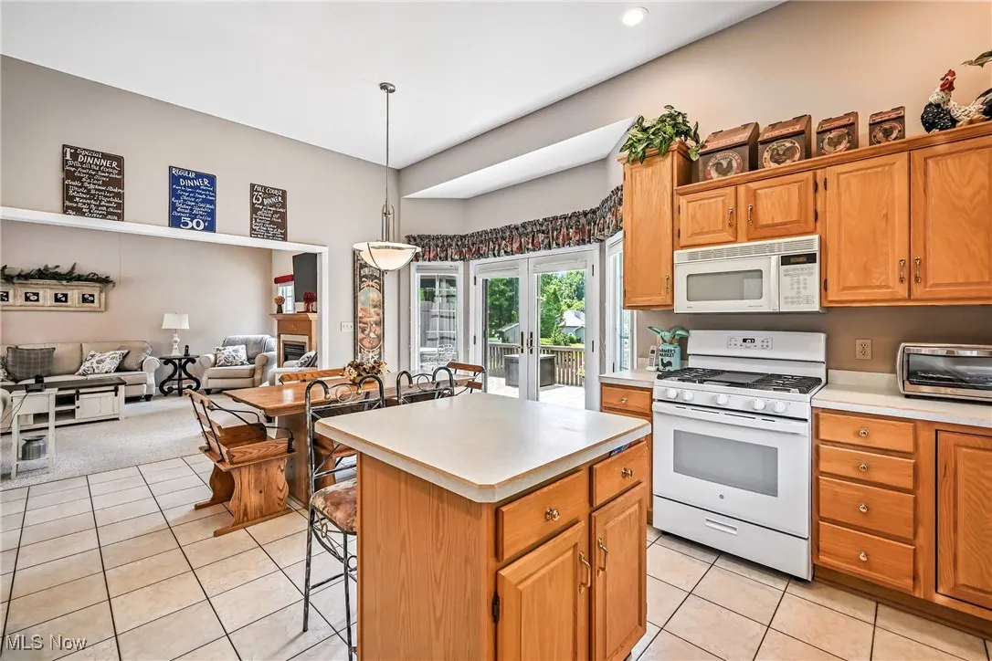 Kitchen featuring white appliances, light tile patterned floors, light countertops, french doors, and recessed lighting
