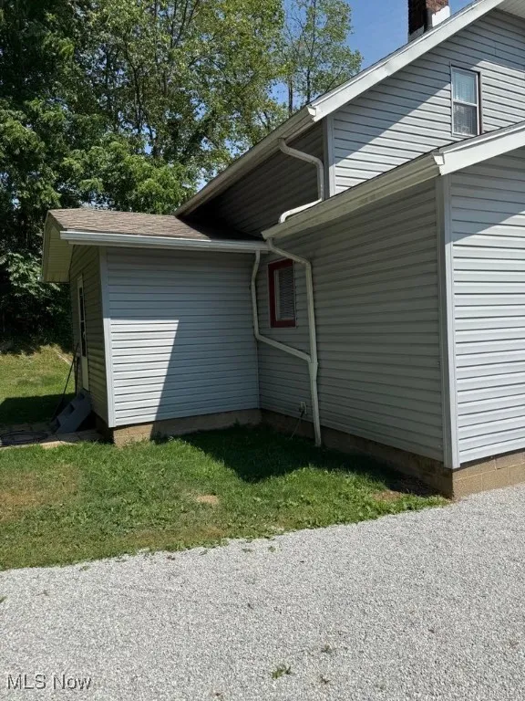 View of side of home featuring a chimney