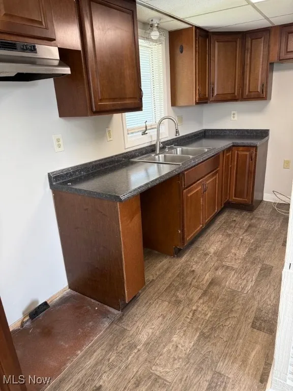 Kitchen featuring luxury vinyl flooring, under cabinet range hood