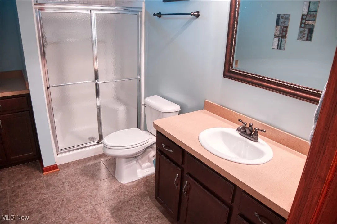 Bathroom featuring vanity, a stall shower, and tile patterned floors