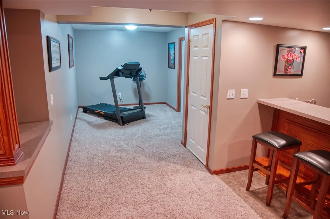 Exercise area featuring light colored carpet, bar area, and recessed lighting