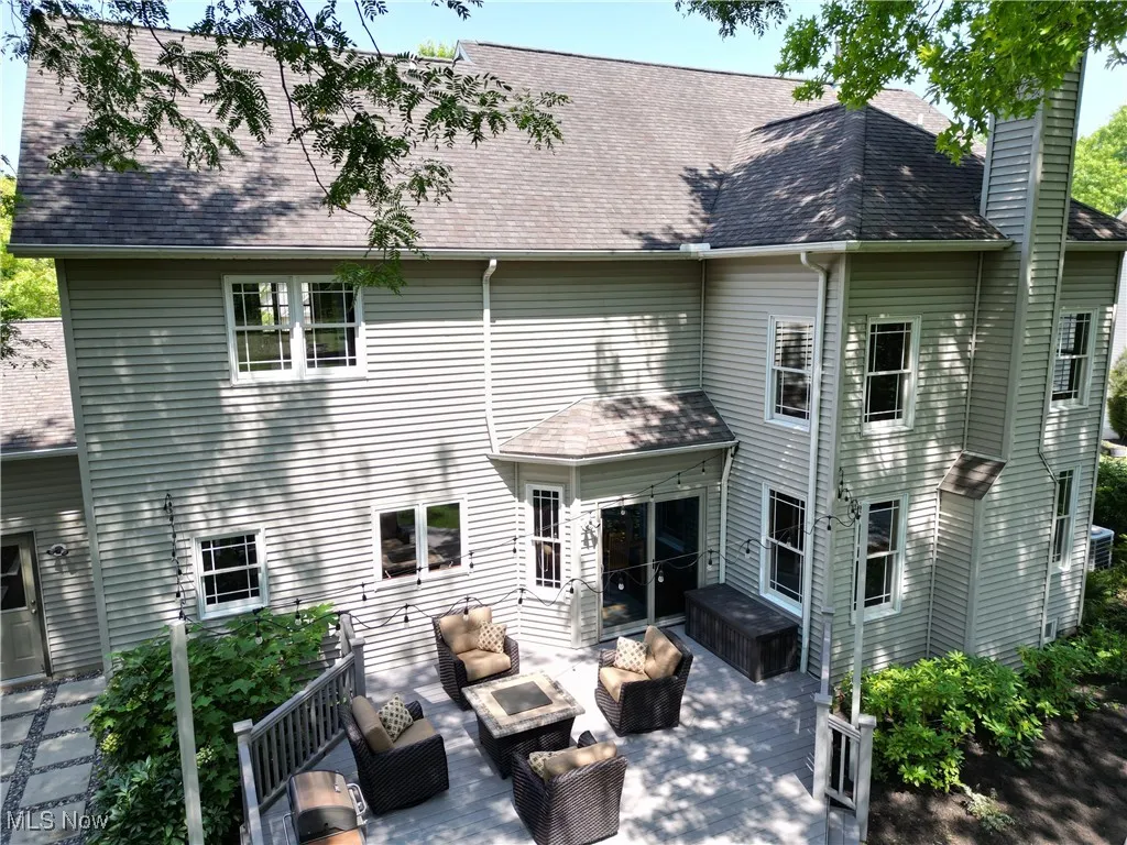 Rear view of house with an outdoor living space, a patio, a shingled roof, and a chimney