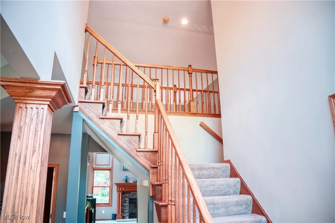 Stairway featuring recessed lighting and a stone fireplace