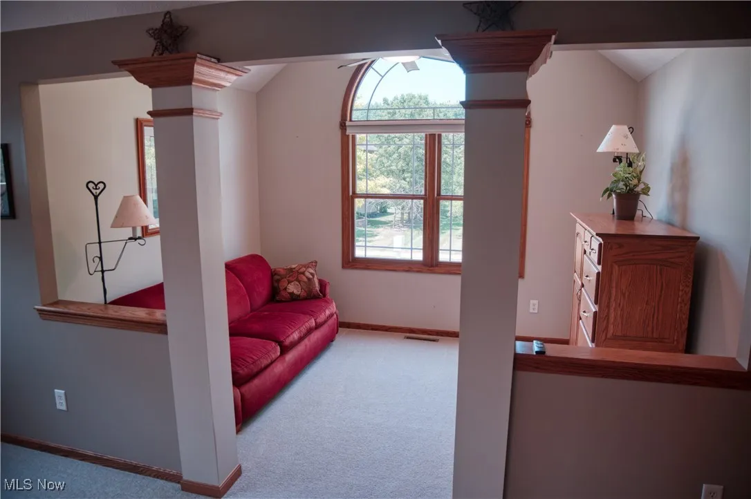 Sitting room featuring ornate columns and carpet floors