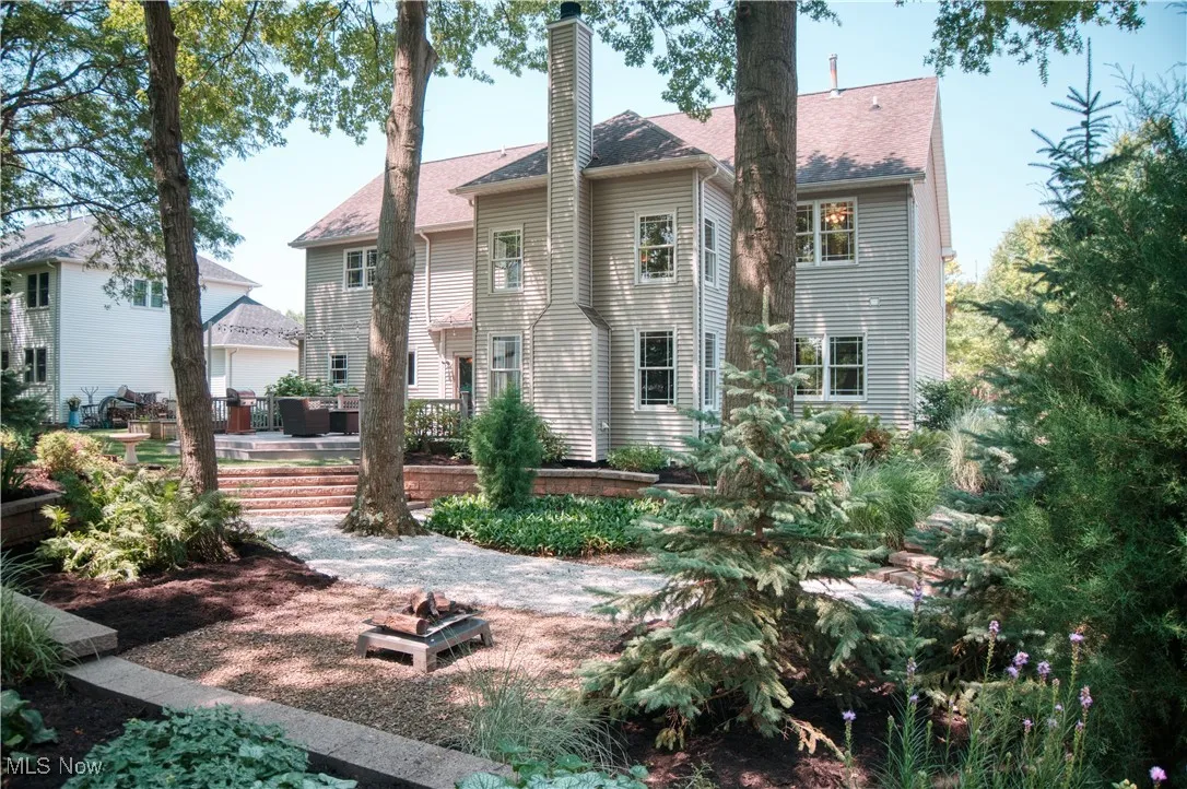 Back of property with a chimney, roof with shingles, and a wooden deck