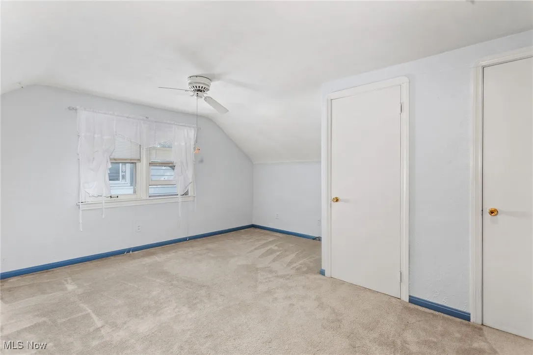 Bonus room with vaulted ceiling, a ceiling fan, and carpet