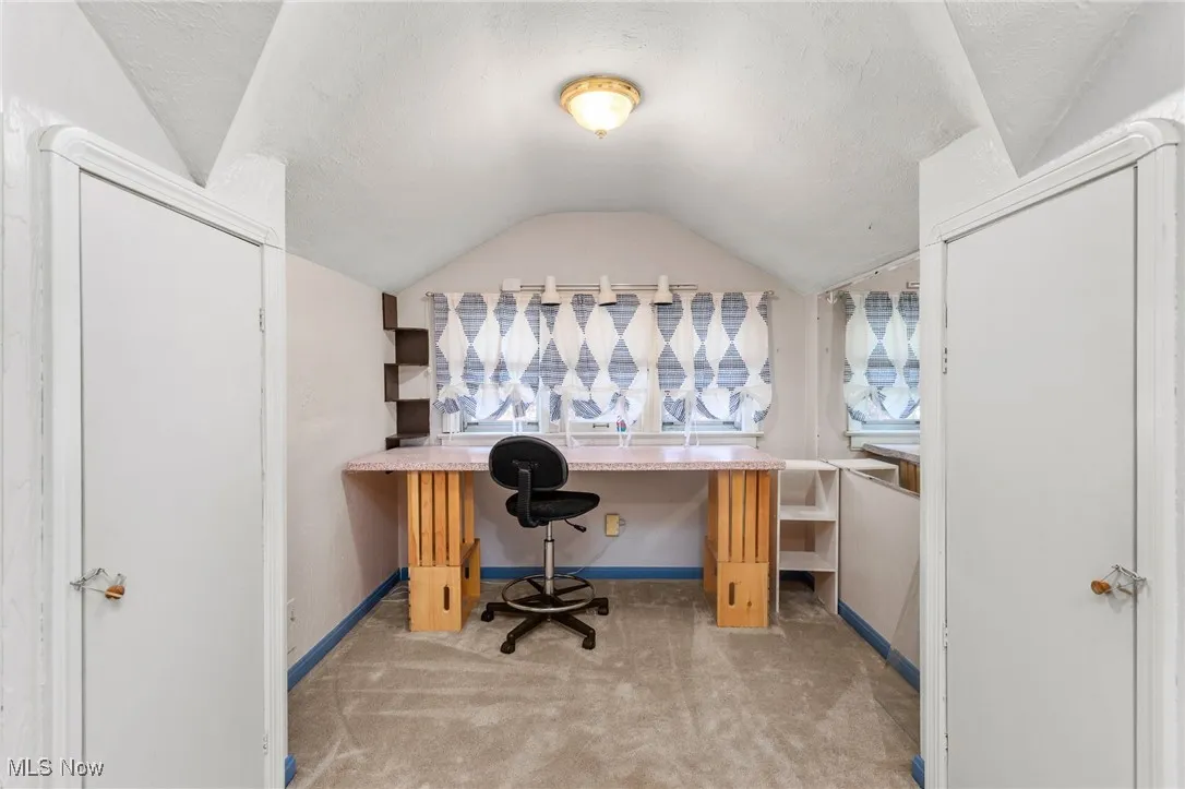 Office featuring lofted ceiling, carpet, and a textured ceiling