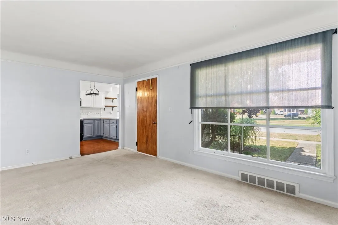 Unfurnished living room featuring carpet floors and baseboards