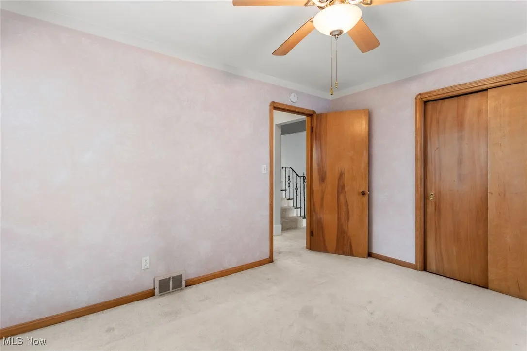 Unfurnished bedroom with carpet flooring, a closet, and a ceiling fan