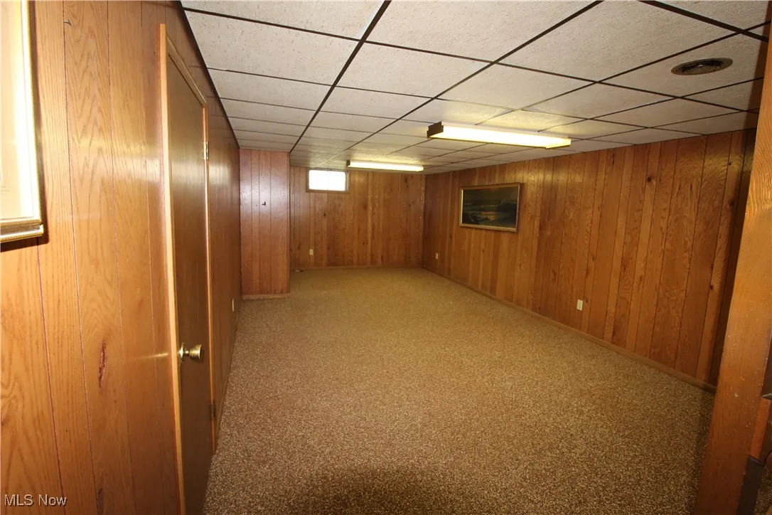 Bonus room with paneling and Pebble Stone flooring