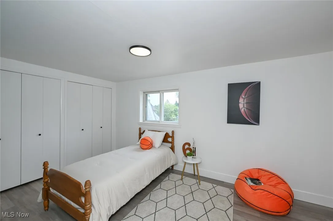 Bedroom with light wood-type flooring and multiple closets