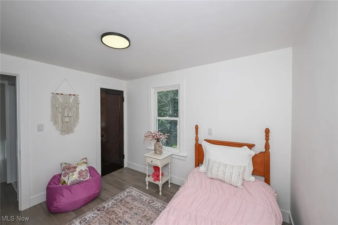Bedroom with wood finished floors and baseboards