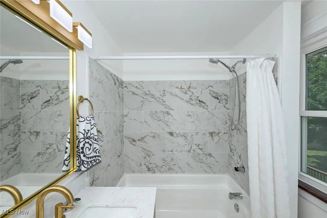 Full bathroom featuring shower / bath combo and vanity
