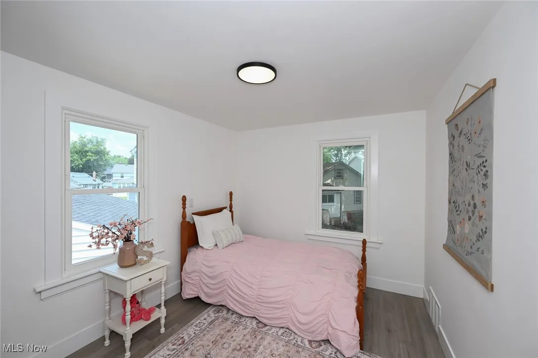 Bedroom with multiple windows and wood finished floors