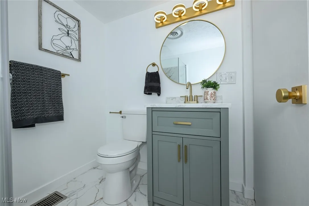 Bathroom featuring marble look tile flooring and vanity