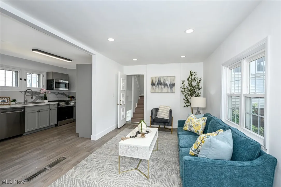 Living area featuring light wood finished floors, stairs, and recessed lighting
