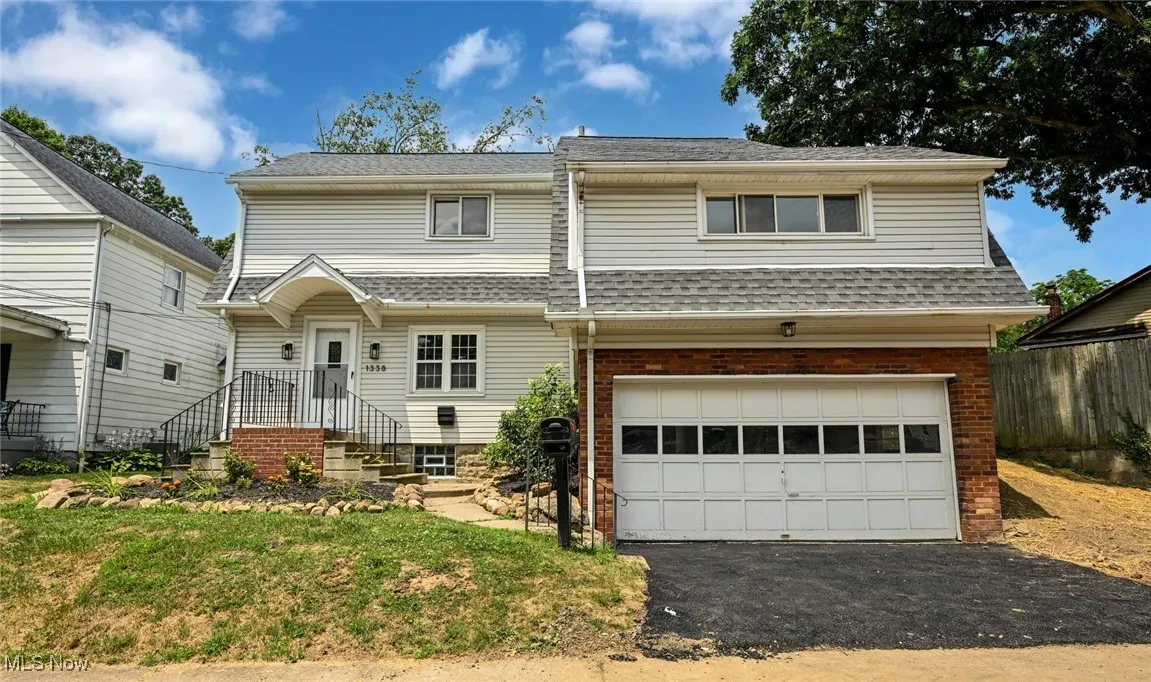 View of front of house featuring asphalt driveway, an attached garage, and brick siding