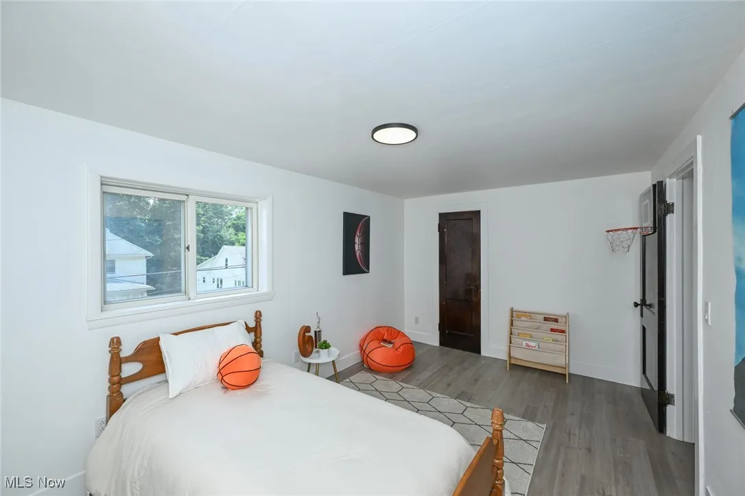 Bedroom featuring wood finished floors and baseboards