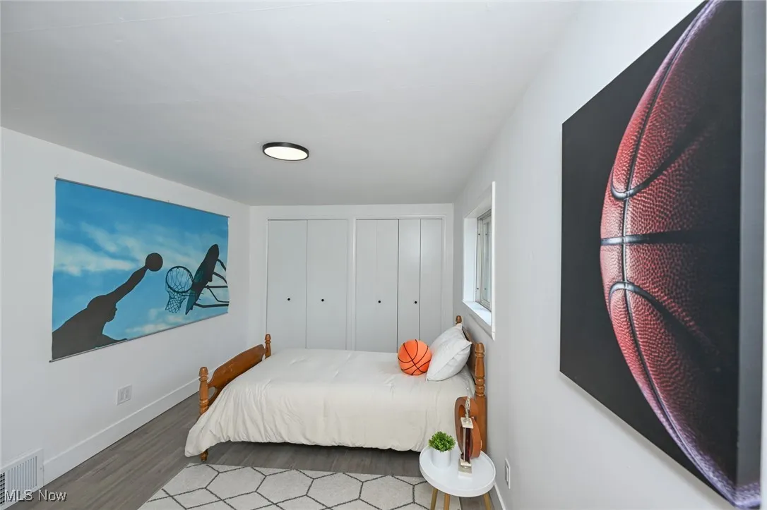 Bedroom with wood finished floors and baseboards