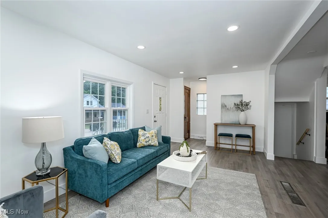 Living room with healthy amount of natural light, wood finished floors, and recessed lighting