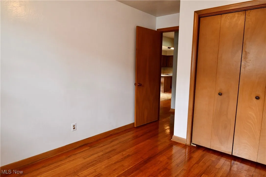 Unfurnished bedroom featuring wood finished floors and a closet