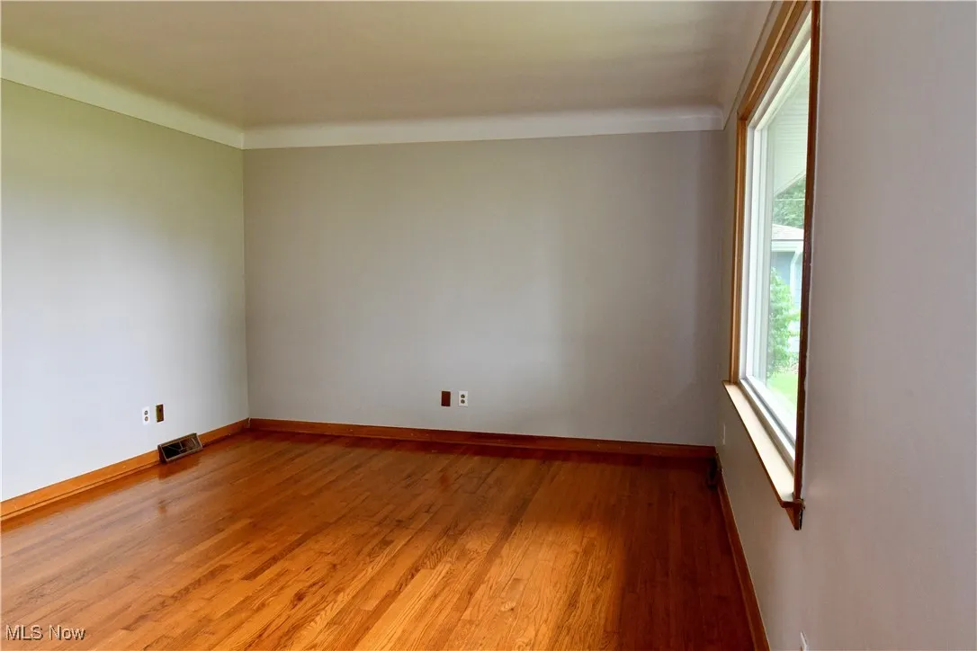Spare room featuring light wood-type flooring and baseboards