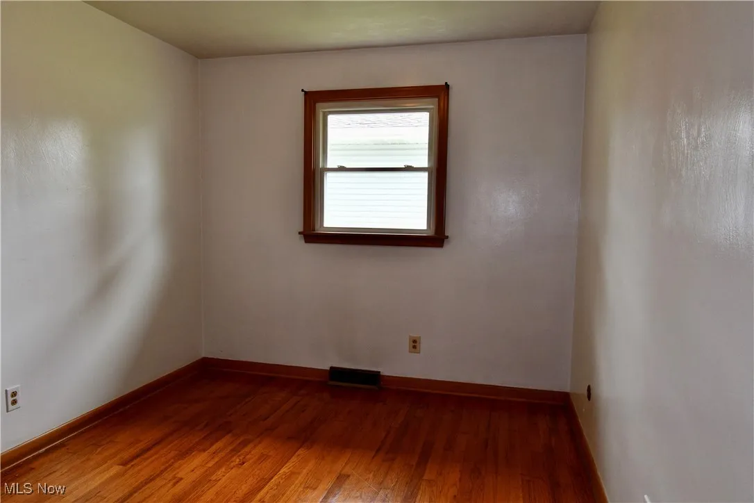 Spare room with wood finished floors and baseboards