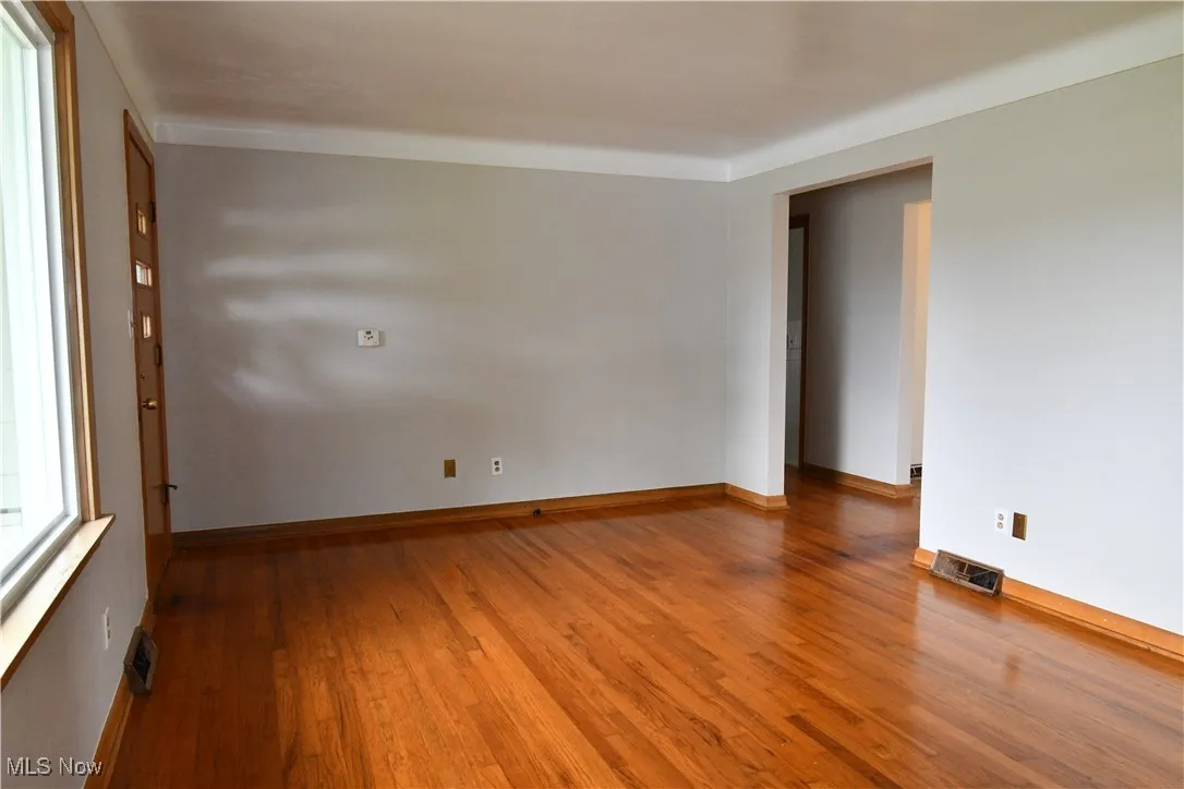 Spare room featuring wood finished floors and baseboards