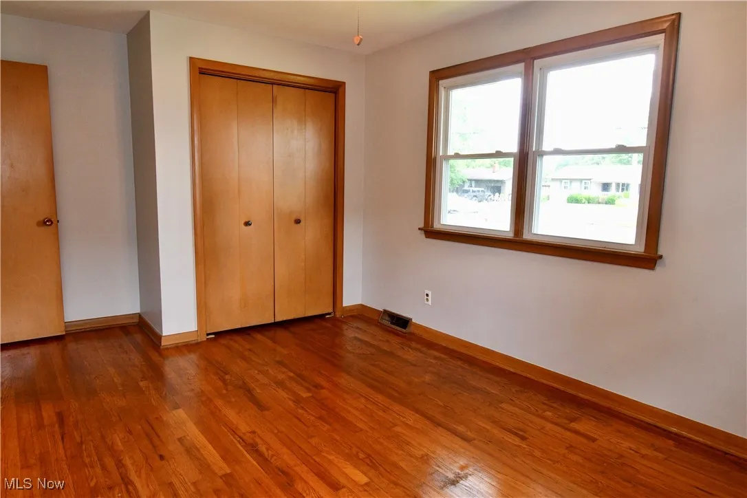 Unfurnished bedroom featuring wood finished floors and a closet