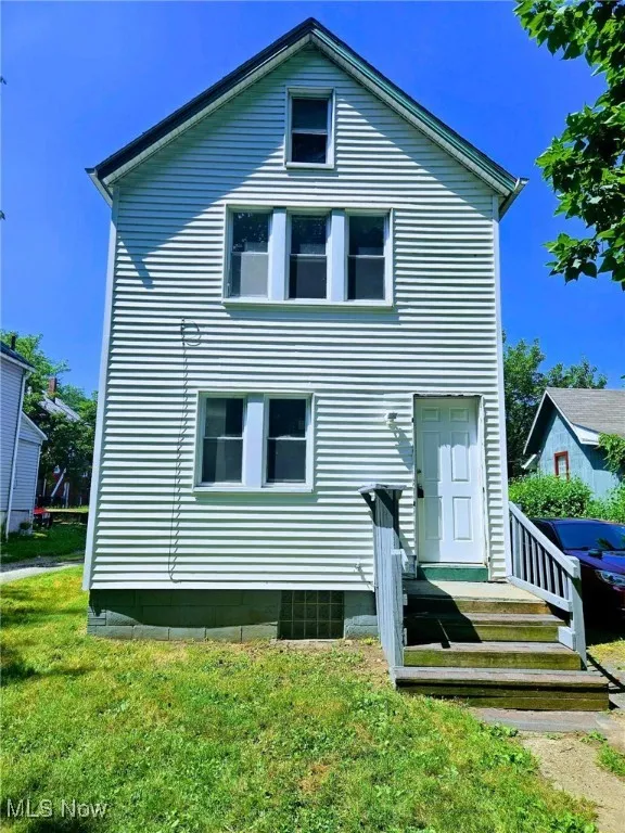 Back of property featuring a lawn