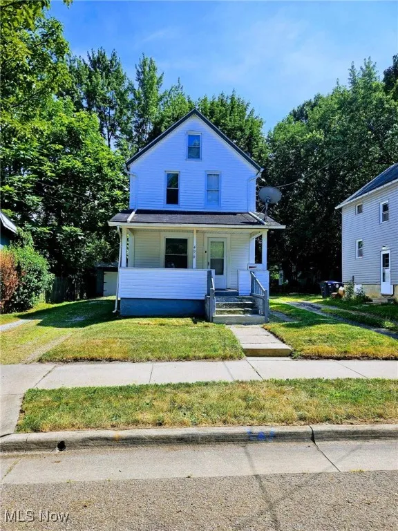 View of front of property featuring covered porch and a front lawn